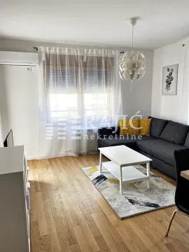 Furnished living room with sofa, coffee table, and window with curtains. - image 2