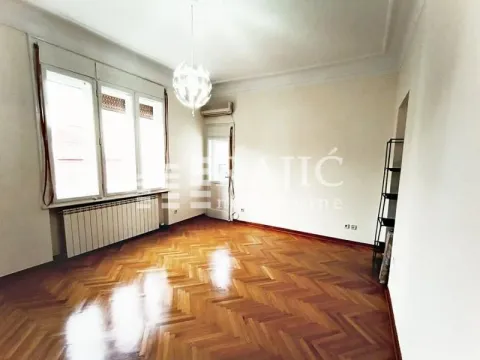 Empty room with parquet flooring and large windows. - image 4