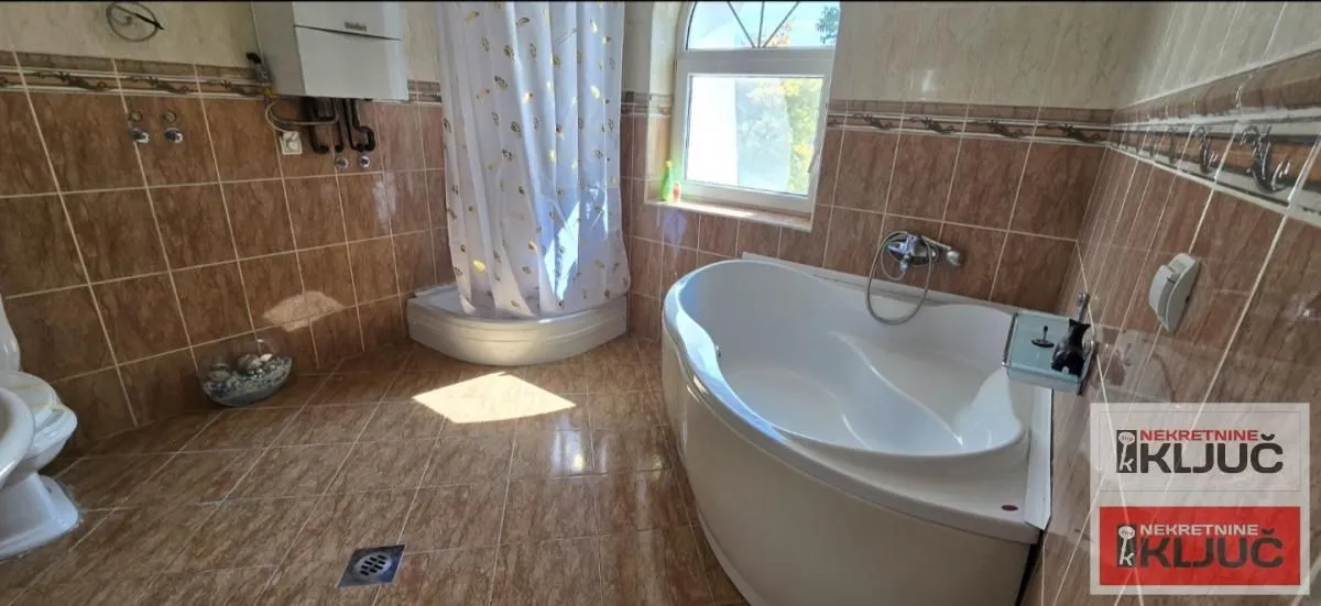 Bathroom equipped with a bathtub, shower cabin, and sanitary ware.