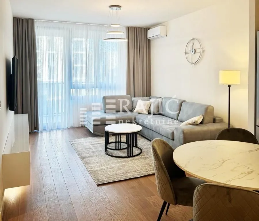 Living room with sofa, dining table and access to the terrace.