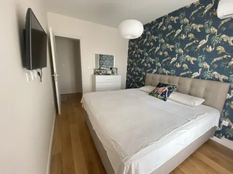 Uređena spavaća soba sa bračnim krevetom i dekorativnim tapetama. - image 7