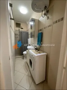 Smaller bathroom with a shower cabin, washbasin, and washing machine. - image 12
