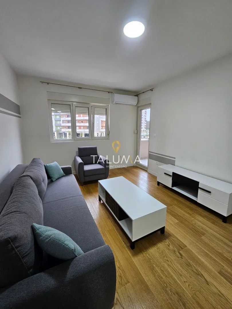 Living room furnished with a sofa, coffee table, and TV cabinet.