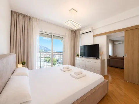 Tidy bedroom with a double bed, TV, and access to the terrace. - image 7