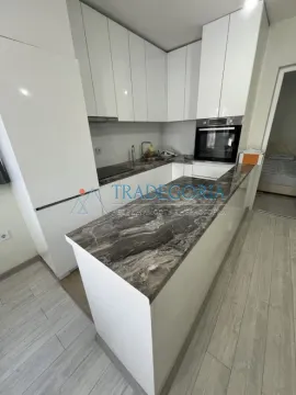 Moderna bijela kuhinja sa šankom i ugradnim elementima. - image 4