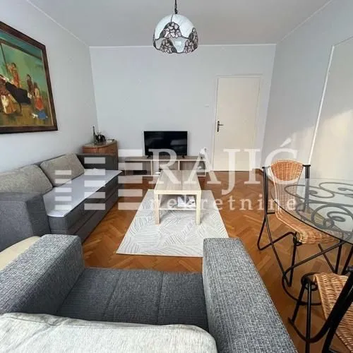 Living room with a sofa, coffee table, and dining table.