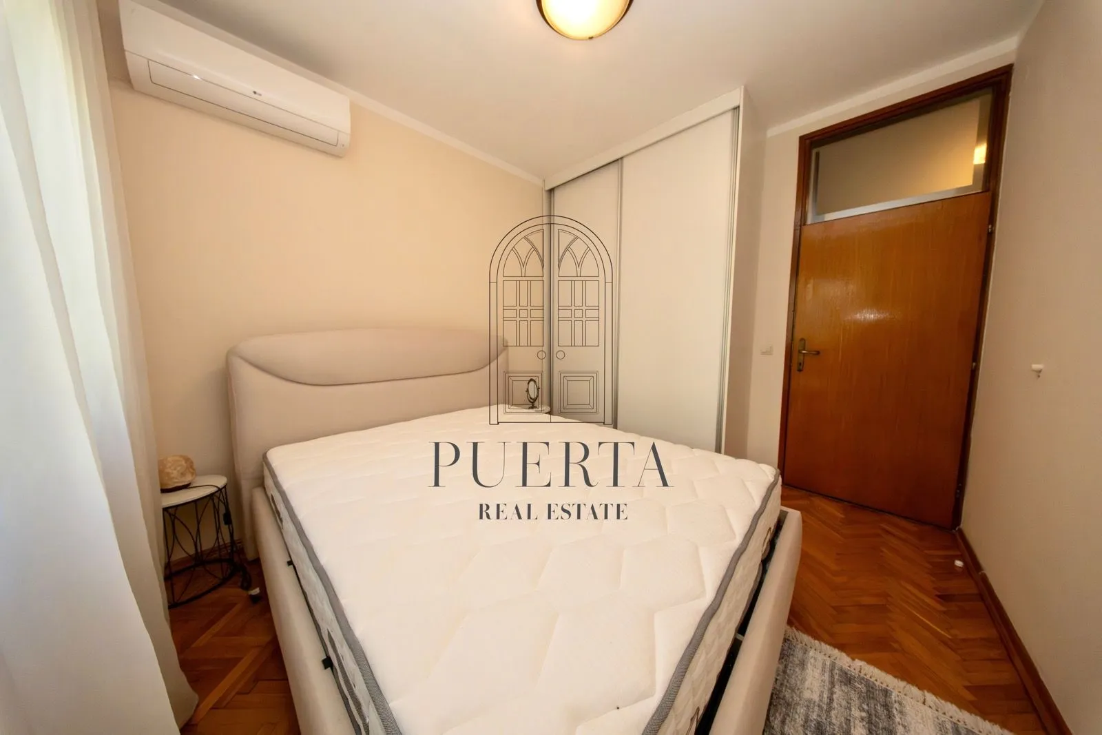 Furnished bedroom with a double bed, wardrobe, and air conditioning.