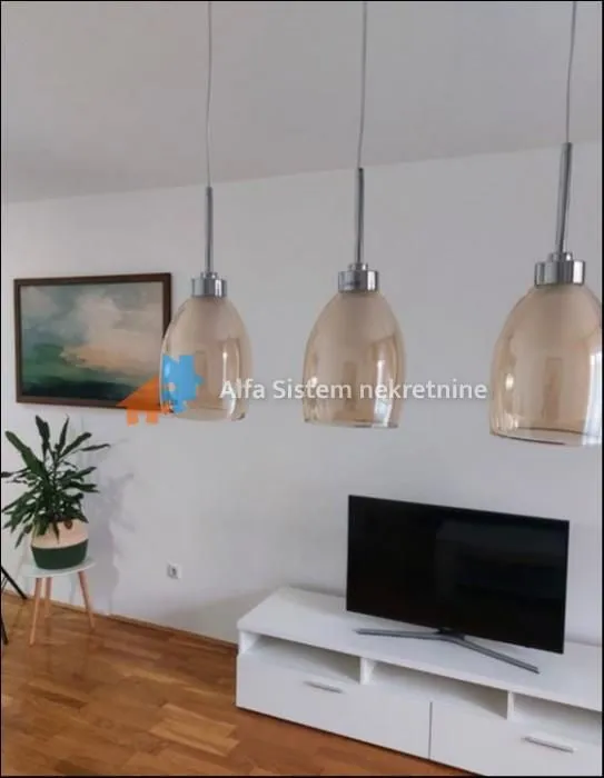 Living room with a white TV unit and pendant lights.