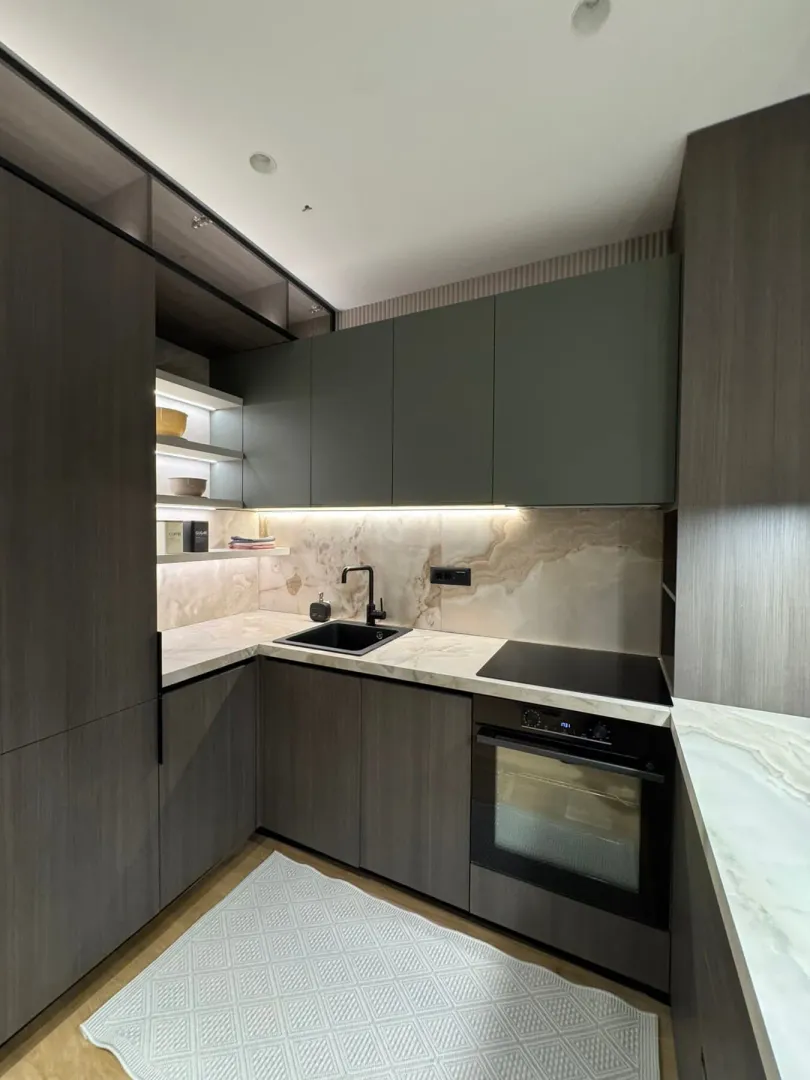 Modern kitchen with dark cabinetry and a built-in oven.