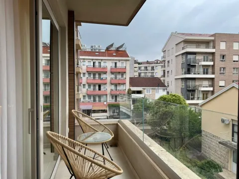 Furnished balcony with chairs and a city view. - image 14