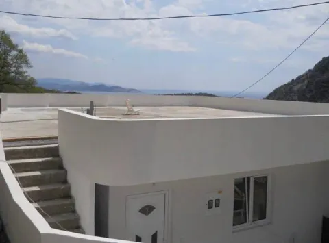 View of a spacious roof terrace and surroundings with a house in the foreground. - image 3