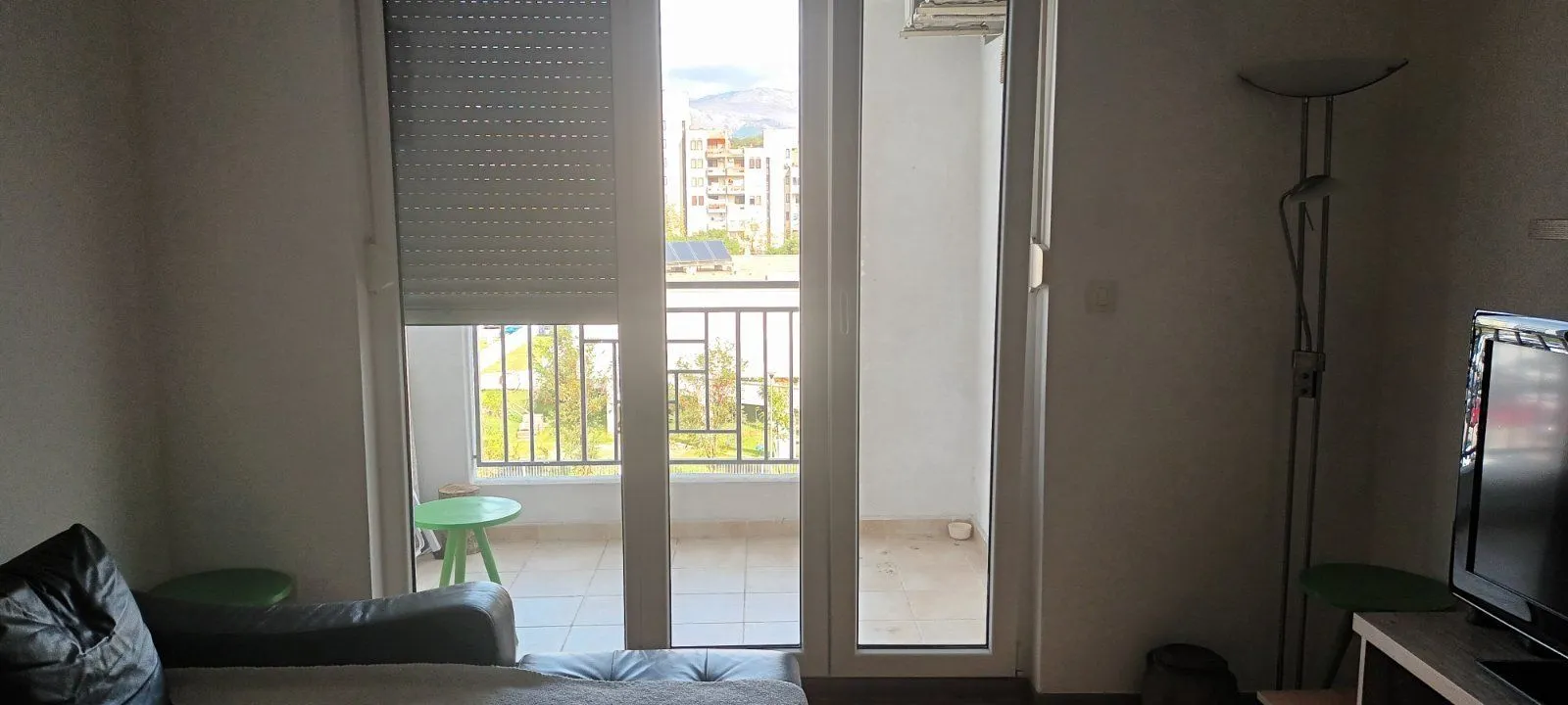 Dnevna soba sa izlazom na zastakljeni balkon.
