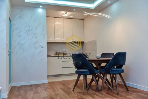 Modern kitchen with dining area and blue chairs. - image 5