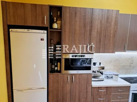 Modern kitchen with wooden cabinetry, white refrigerator, and built-in appliances. - image 8