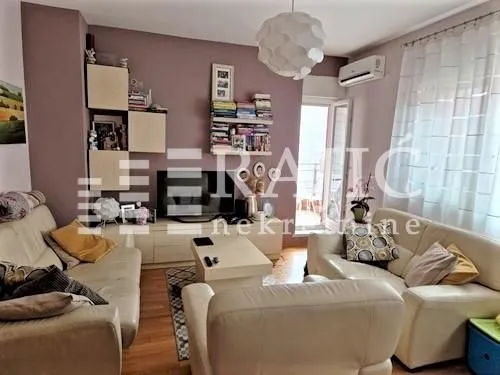 Living room with sofa set, TV, and access to the terrace.