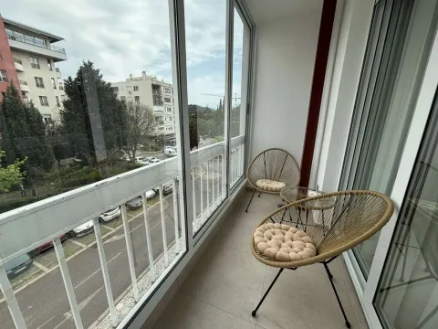Zastakljeni balkon sa garniturom za sjedenje i pogledom na ulicu. - image 6