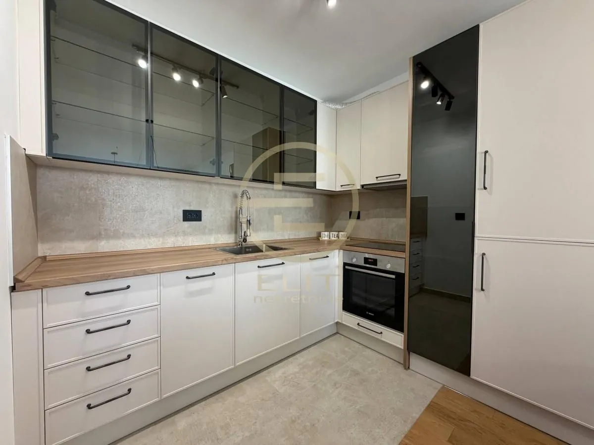 Modern kitchen with white cabinetry and built-in appliances.