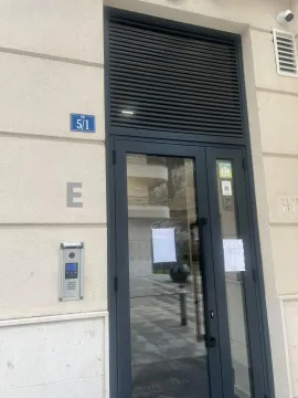 Entrance to a residential building with a modern intercom and glass door. - image 2