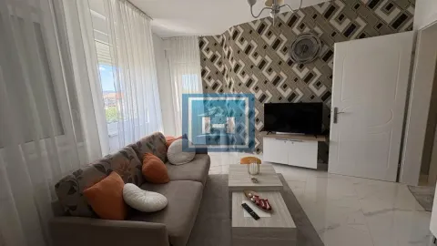 Dnevna soba sa garniturom, televizorom i dekorativnim tapetama na zidu. - image 5