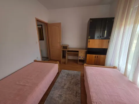 Bedroom with two single beds, a desk, and a wardrobe. - image 9