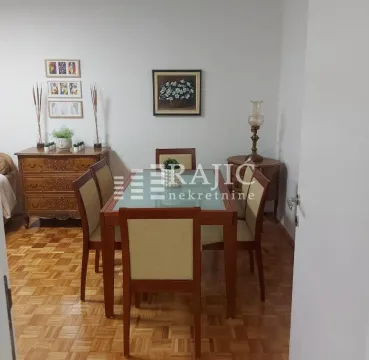 Dining room with a wooden table, chairs, and a chest of drawers. - image 3