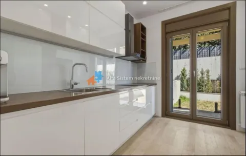 Modern white kitchen with a sink and a view of the yard. - image 4