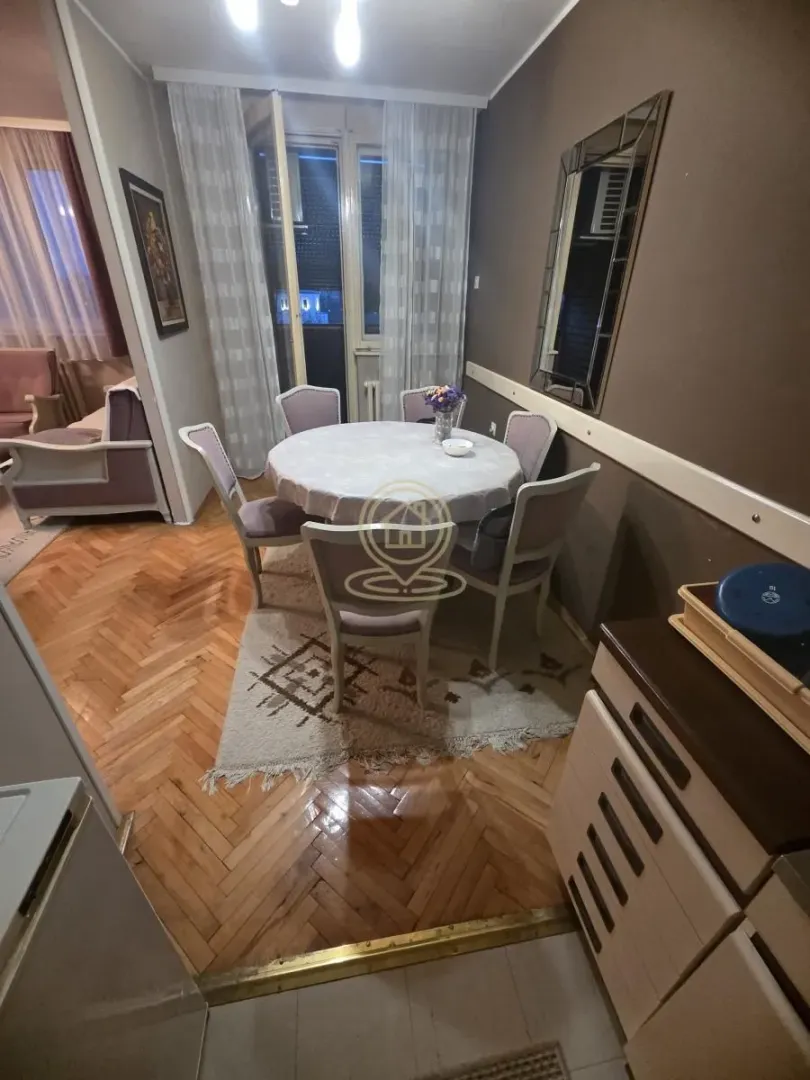 Trpezarija sa okruglim stolom i stolicama, parket na podu.