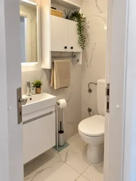 View of a modern bathroom equipped with a washbasin and toilet. - image 11