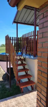 Drvene stepenice vode do natkrivene terase sa drvenom ogradom u dvorištu. - image 17