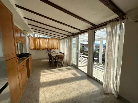Living room with a dining area and large glass surfaces leading to the terrace. - image 9