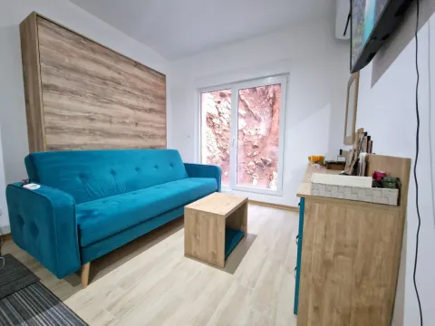 Living room with a blue sofa, wooden coffee table, and dresser. - image 9