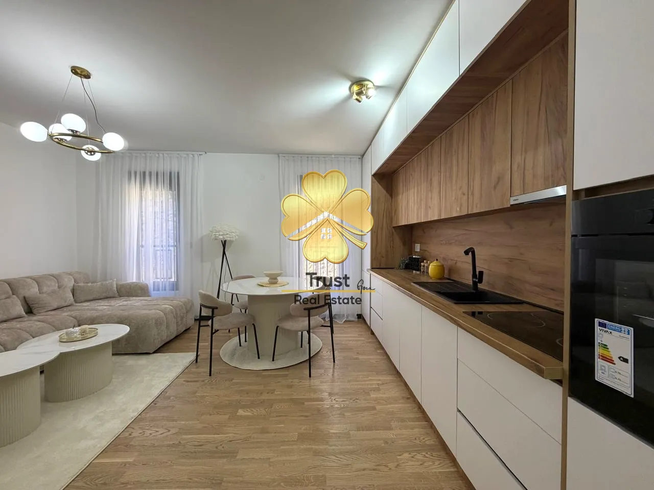 Modern kitchen with a dining area and living room in light tones.