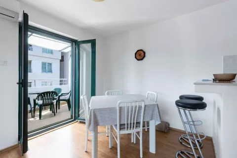 Trpezarija sa stolom i stolicama i izlazom na balkon. - image 2