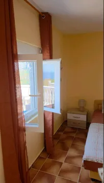 Small bedroom with a bed, nightstand, and a window with a view. - image 11