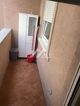 Manji balkon sa keramičkim pločicama, belim ormarićem i priborom za čišćenje. - image 7