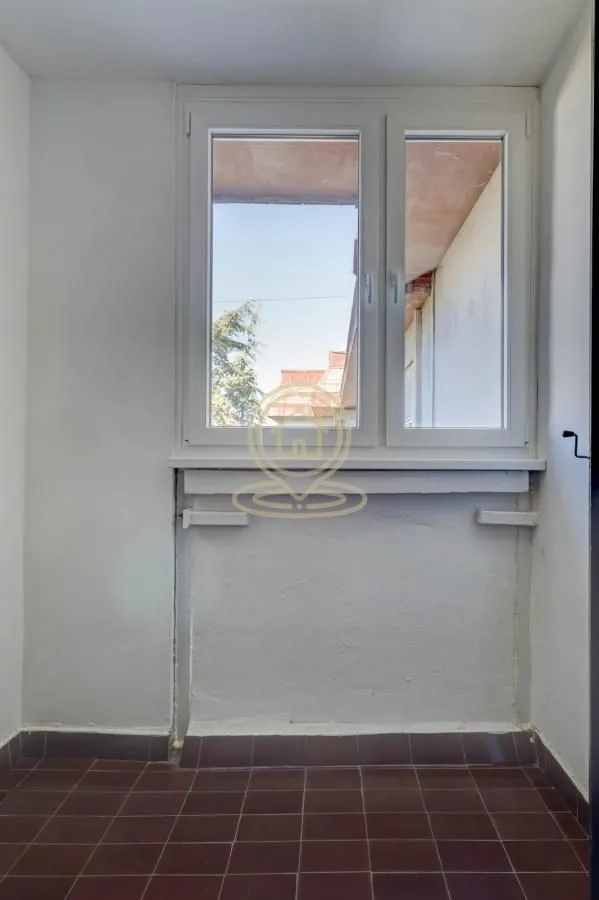 Small room with a window and tiled floor.