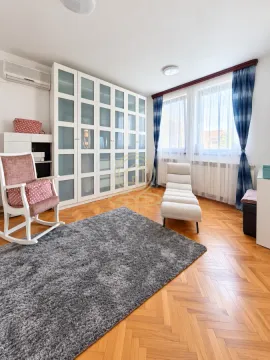 Bedroom with a large built-in wardrobe, a rocking chair, and parquet flooring. - image 7