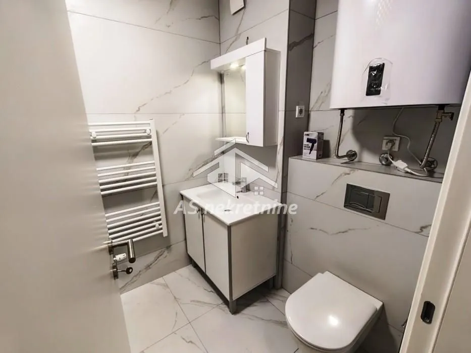Modernly equipped bathroom with a shower cabin, washbasin, and toilet.