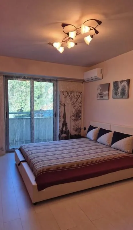 Namještena spavaća soba sa velikim krevetom i izlazom na balkon.
