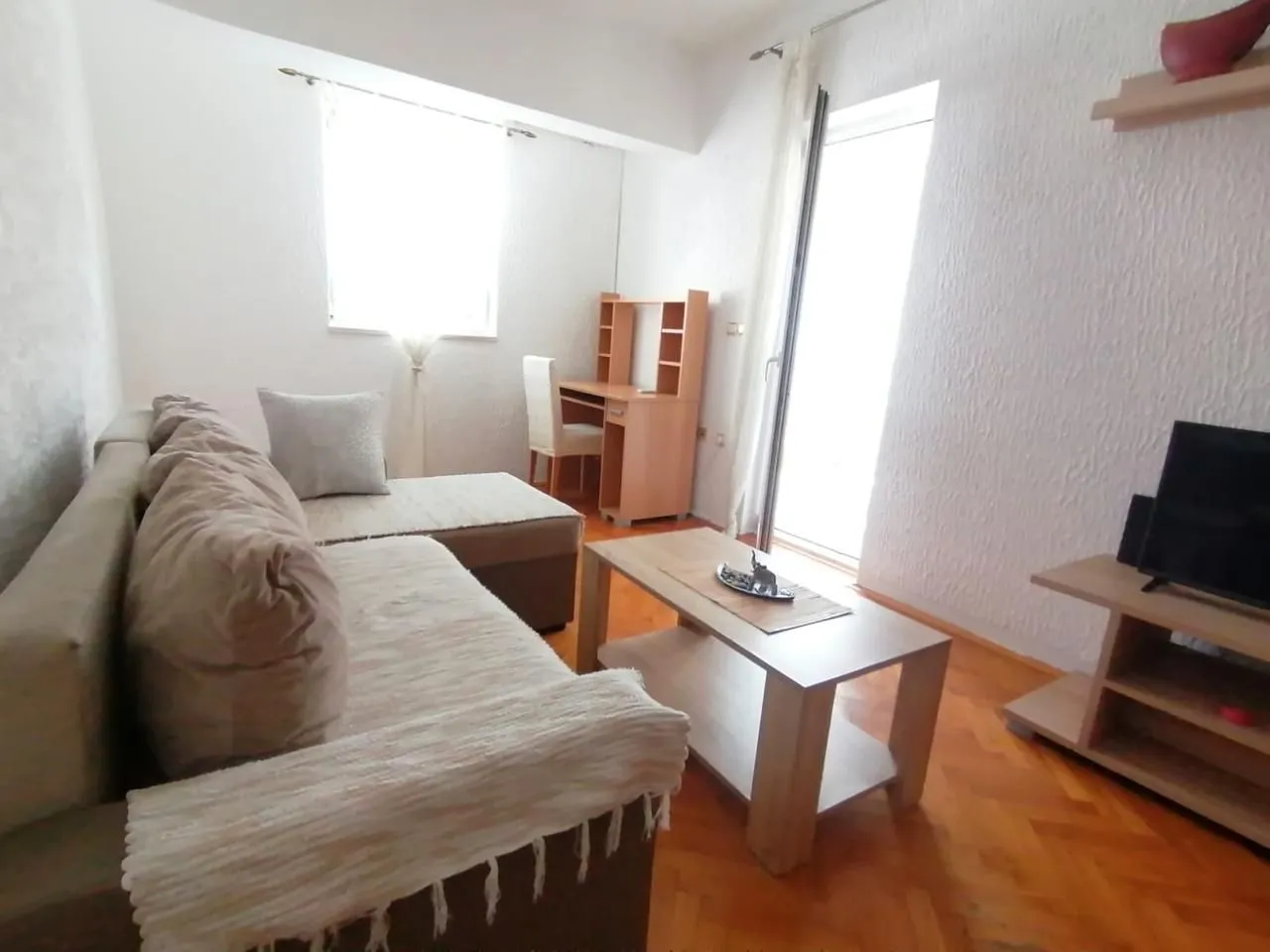 Living room with sofa, coffee table and TV unit.
