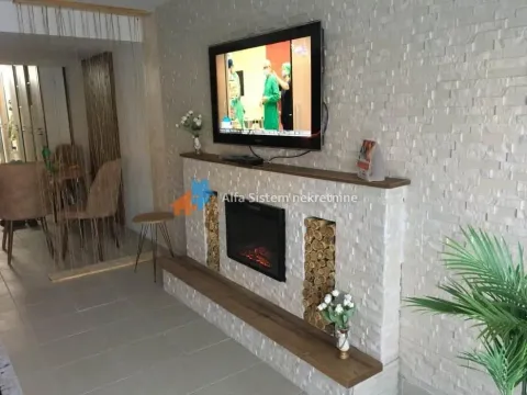 Living room with a decorative stone wall and a built-in fireplace. - image 5