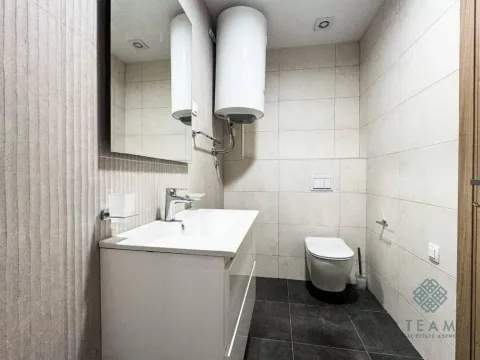 Savremeno opremljeno kupatilo sa umivaonikom, ogledalom i toaletom. - image 6