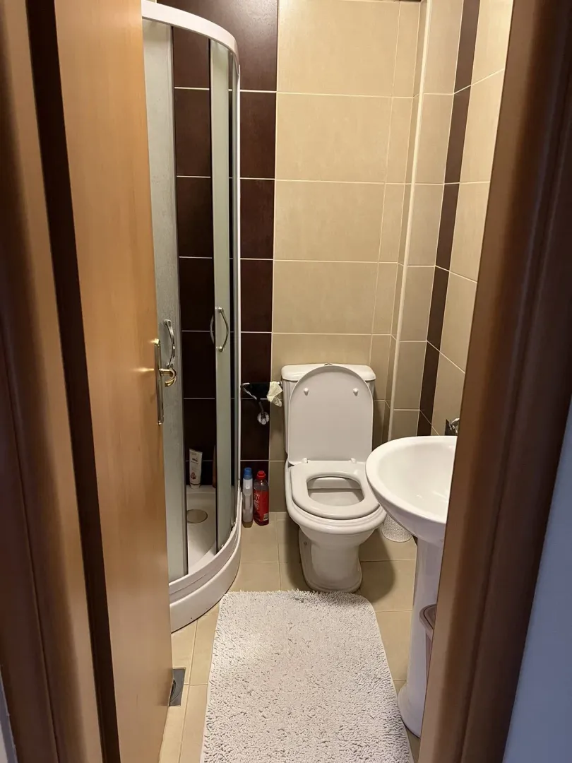 Bathroom with a shower cabin, sink, and toilet.