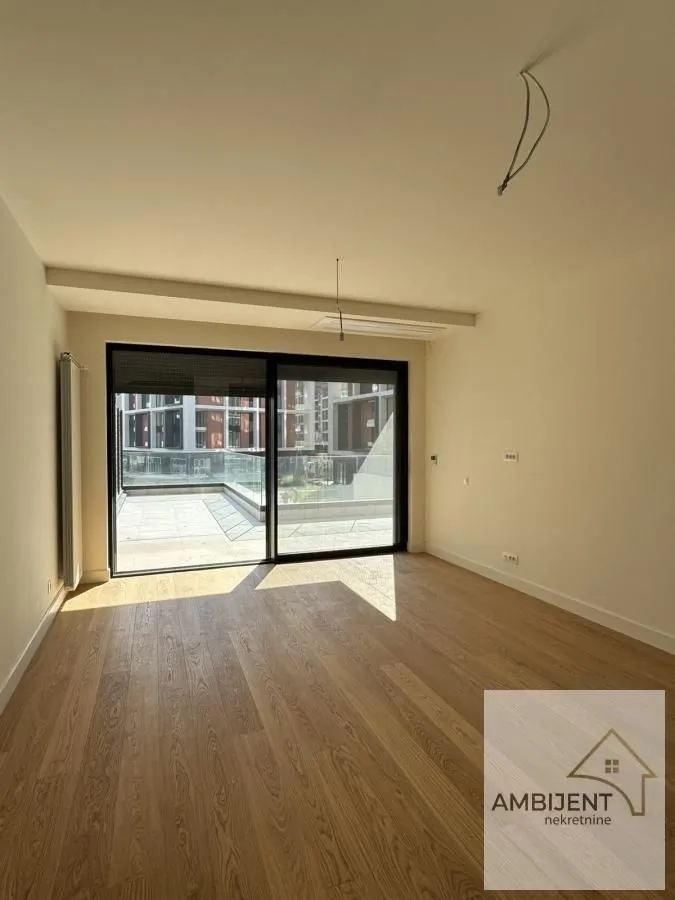 Unfurnished room with wooden flooring and access to the terrace.