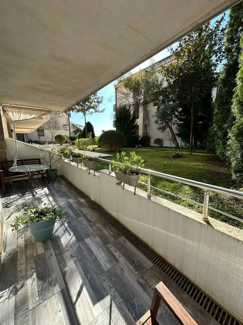 Spacious covered terrace overlooking the yard and greenery.