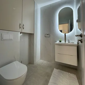 Moderne opremljeno kupatilo sa bijelim pločicama i osvijetljenim ogledalom. - image 8