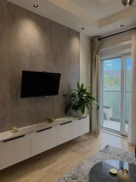 Modern living room with a TV wall unit, white console, and access to the terrace. - image 4