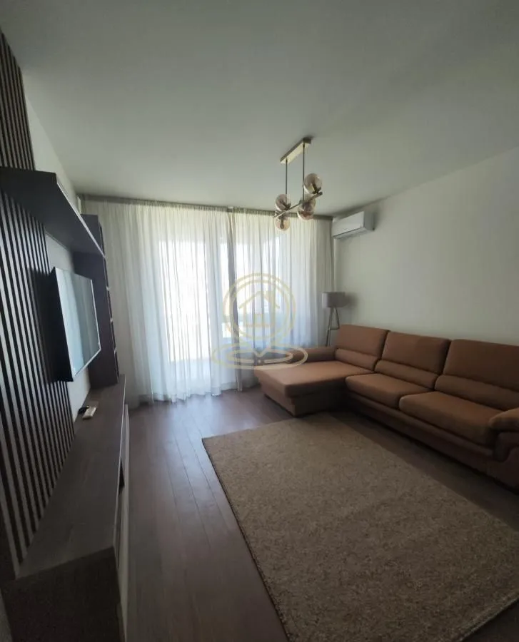 Living room with a sofa, TV, and a large window.