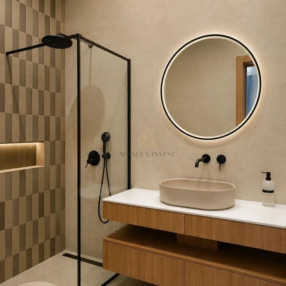 Modern bathroom featuring a walk-in shower, wooden vanity unit, and a round backlit mirror.