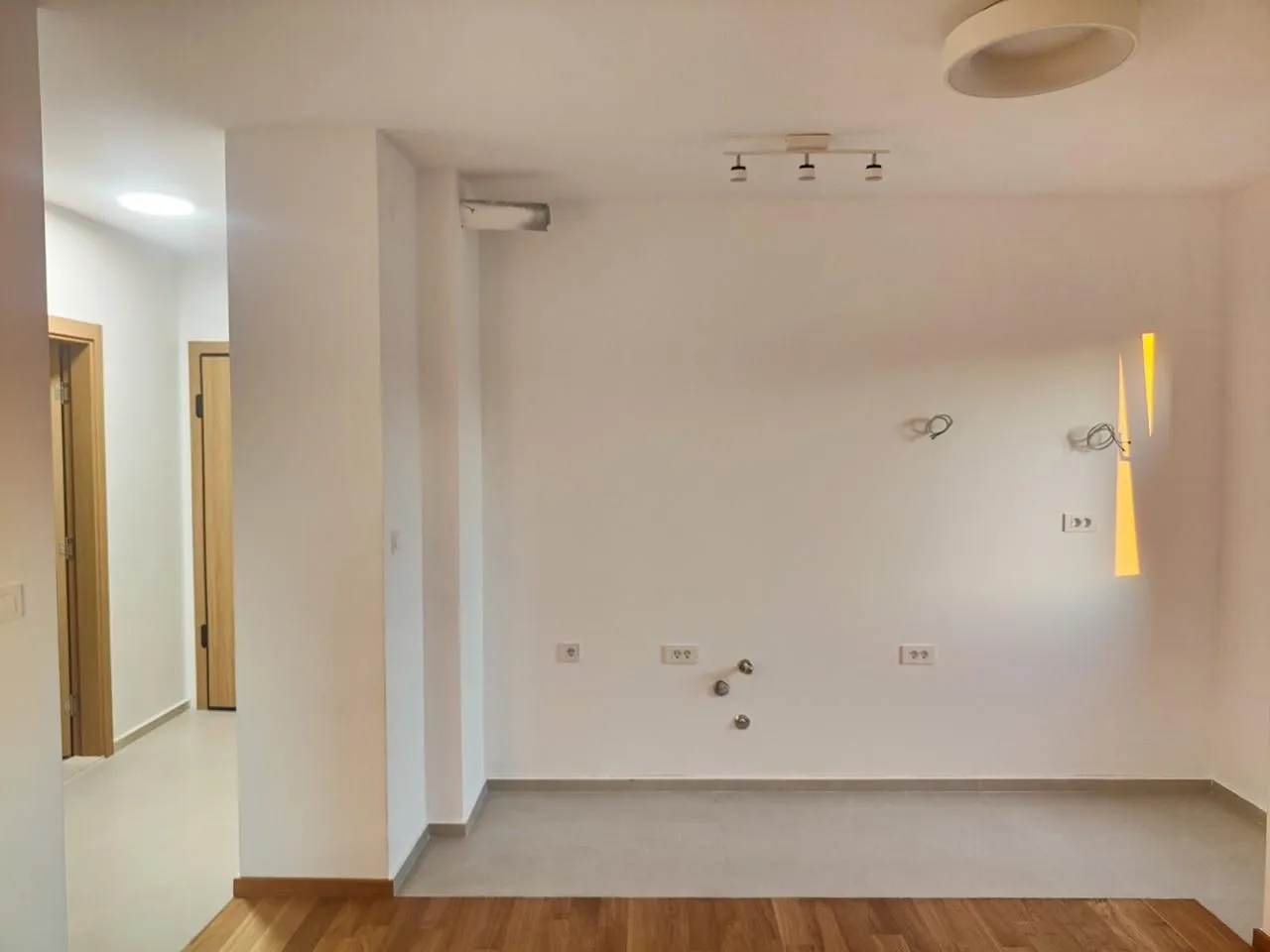 Empty space designated for a kitchen with wall connections.